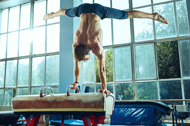 The sportsman during difficult exercise, sports gymnastics - 写真・画像