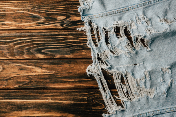 top view of light denim textile on wooden tabletop - Photo, Image