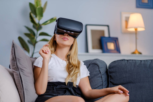 Attractive young woman in VR headset gesturing and smiling - Fotografie, Obrázek