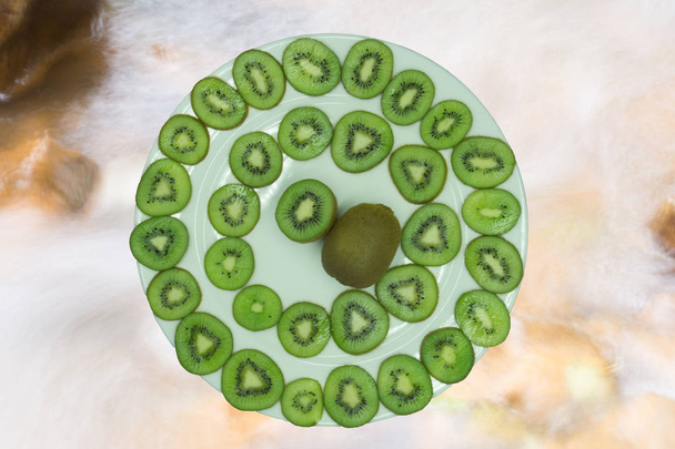 Kiwi sliced on wooden plate and white background - Фото, изображение