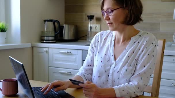 Vrouw betaalt online met haar creditcard en notebook - Video