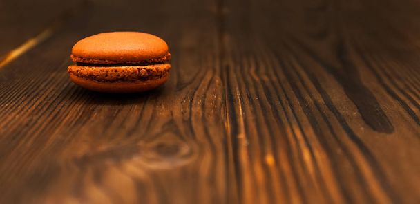 Французский шоколадный макарон на тёмном деревянном столе. Селективный фокус
 - Фото, изображение