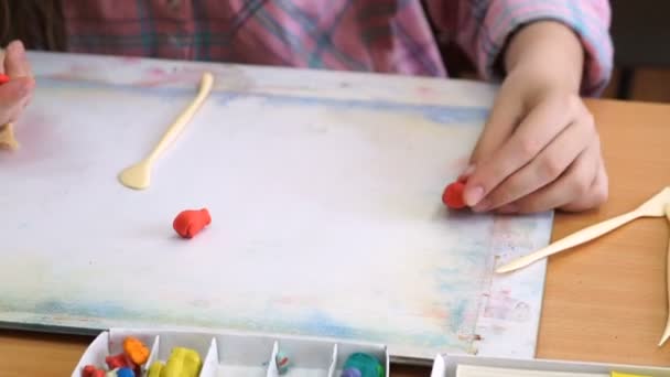 a pultnál ülő kislány sculpts a különböző számok - Felvétel, videó