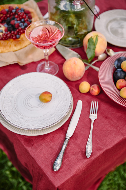 platos, tenedor y cuchillo en la mesa en el jardín
 - Foto, Imagen