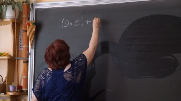 Δάσκαλος γράφοντας υπολογισμούς στον μαυροπίνακα - Πλάνα, βίντεο