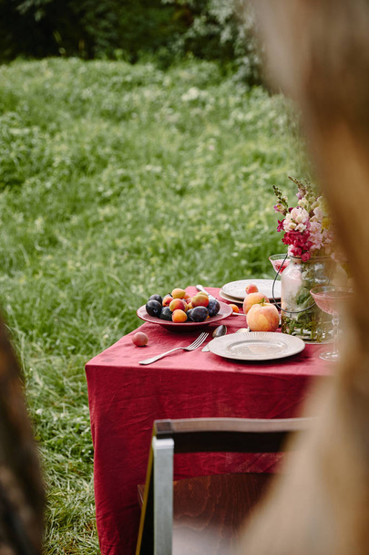 bukiet kwiatów i dojrzałe owoce na stole w ogrodzie - Zdjęcie, obraz
