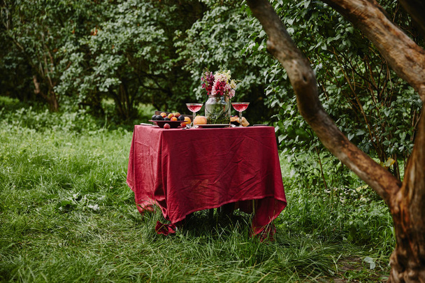 mesa servida con comida y bebidas en el jardín
 - Foto, Imagen