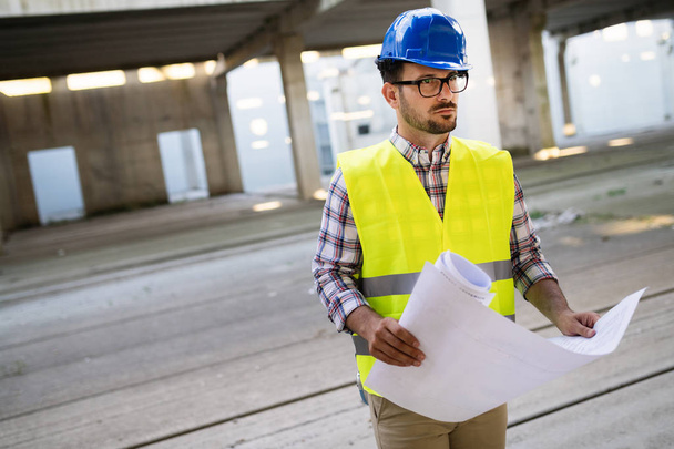Picture of construction site engineer looking at construction plan - Photo, Image