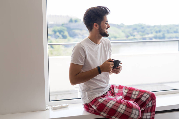 Young man drinking coffee in the morning - Фото, зображення