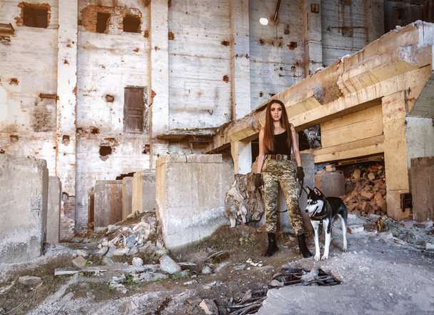 militair meisje met husky hond op de ruïnes van verlaten gebouw - Foto, afbeelding