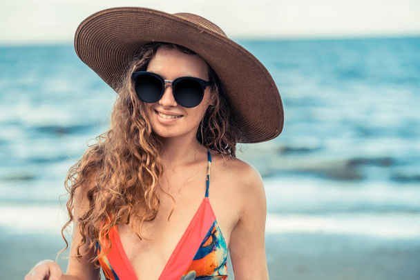 熱帯のビーチでの休暇旅行のための夏で良い時間を過ごして水着を着て幸せな若い女. - 写真・画像