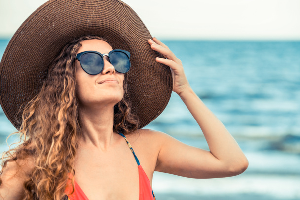 Boldog fiatal nő visel fürdőruhát birtoklás időben trópusi tengerparton nyáron vonatkozó nyaralás utazás. - Fotó, kép