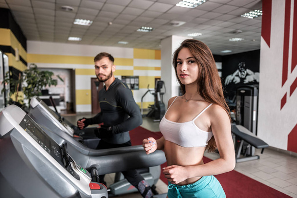 spor salonunda treadmill sportif genç çift - Fotoğraf, Görsel