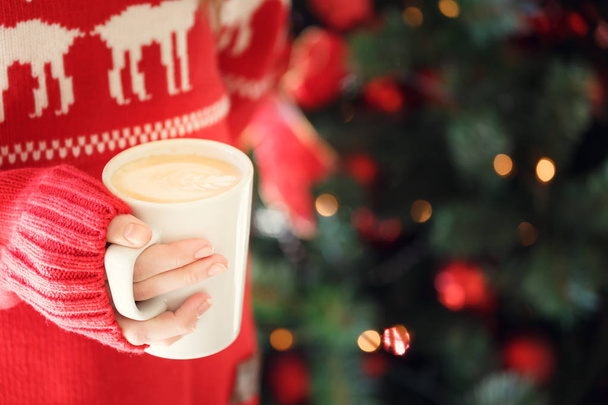Girl holding a cappuccino cup. Concept of Christmas holiday. Holiday background. Warm tone. Horizontal - Photo, Image