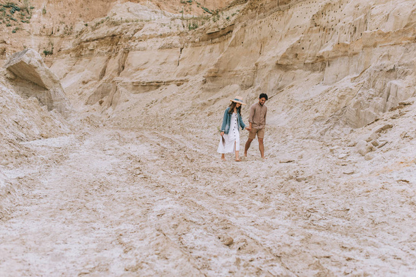 beau couple tenant la main et marchant dans le canyon de sable
  - Photo, image