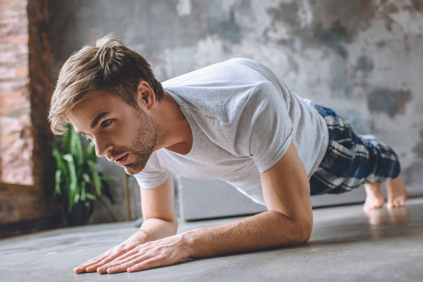 serious man doing plank during morning time at home  - Photo, Image