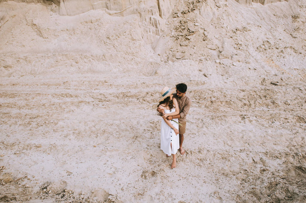 vysoký úhel pohled mladého páru objímání v písku canyon - Fotografie, Obrázek