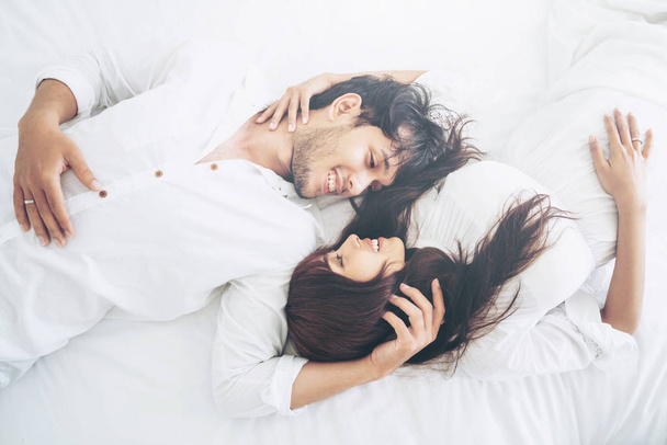 Happy young couple relaxing in home bedroom after waking up in the morning. - Foto, Imagem