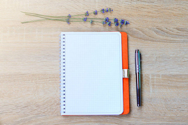 Bloc de notas de cuero al aire libre, pluma estilográfica y flores (lavanda) en el escritorio
.  - Foto, imagen
