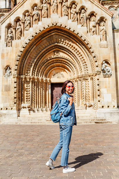 Viaggiatore misto donna corsa con zaino ammirando attrazioni turistiche e destinazioni in Europa. Cappella Jaki nel castello di Vajdahunyad a Budapest
 - Foto, immagini