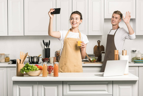 girlfriend taking selfie with smartphone in kitchen - Foto, imagen