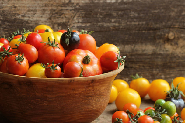 Wooden bowl with fresh vine ripened heirloom tomatoes from farmers market - Fotoğraf, Görsel
