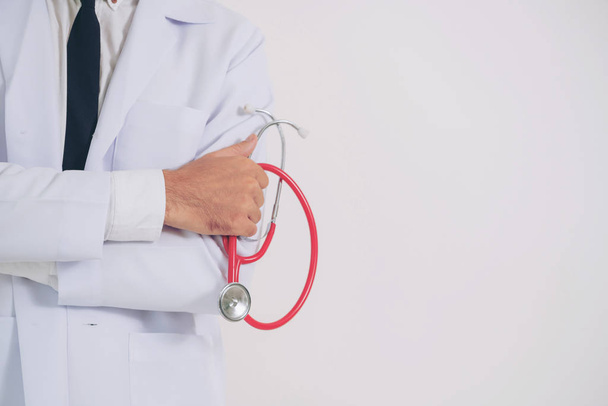 Médecin homme tenant stéthoscope sur fond blanc. Concept médical et de santé
. - Photo, image