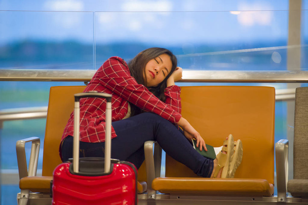 estilo de vida retrato de joven bastante cansado y agotado mujer turista asiática coreana en el aeropuerto durmiendo aburrido sentado en la puerta de embarque esperando un vuelo retrasado o cancelado
 - Foto, Imagen