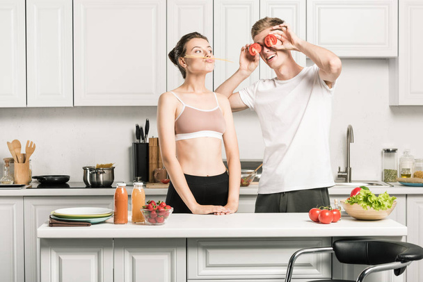 молода пара розважається під час приготування макаронних виробів на кухні
 - Фото, зображення