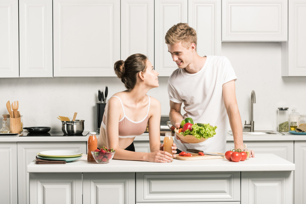 young couple looking at each other in kitchen - 写真・画像