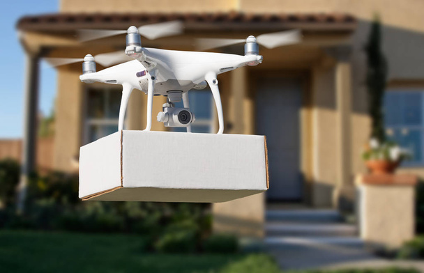 Беспилотные летательные аппараты (БПЛА) Quadcopter Drone Delivering Package At House
. - Фото, изображение