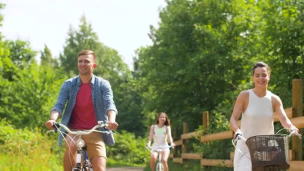 happy friends riding fixed gear bicycles in summer - Materiał filmowy, wideo