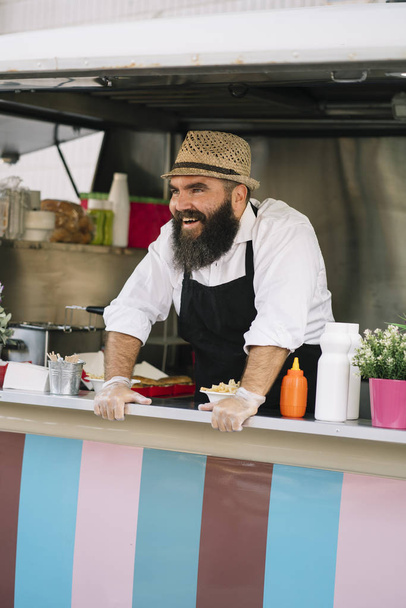Venditore di cibo sorridente con barba nel truk alimentare
 - Foto, immagini