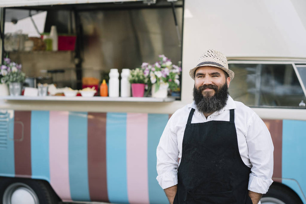 Portrait of a smiling food vendor with a food truk - Foto, Imagem