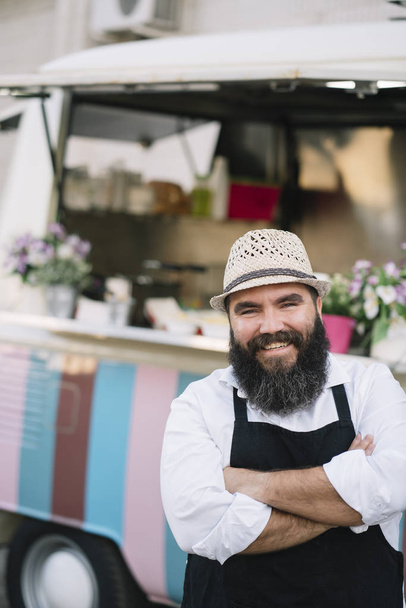 Portrait of a smiling food vendor with a food truk - Фото, зображення