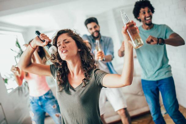 Gruppe von Freunden, die zu Hause Karaoke spielen, Konzept der Freundschaft und Home Entertainment  - Foto, Bild
