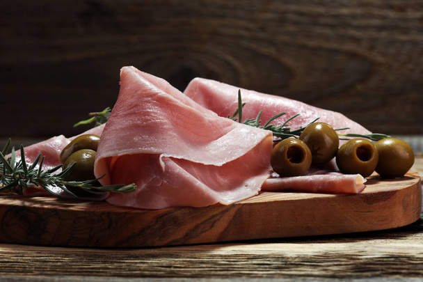 Sliced ham on wooden cutting board. Fresh prosciutto. Pork ham sliced. - Photo, Image