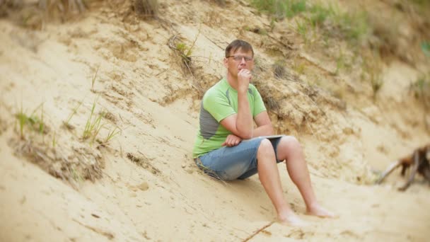 Kypsä mies hiekkarannalla polttaa höyryä
 - Materiaali, video