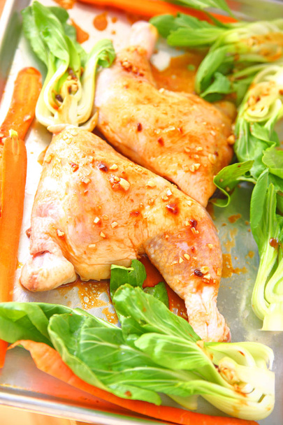 Gambe di pollo intere con una marinata di soia all'aglio su una padella con baby bok choy e carote
 - Foto, immagini
