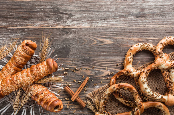 Composição de pretzels com decoração e salsichas na massa de farinha na mesa de madeira
 - Foto, Imagem