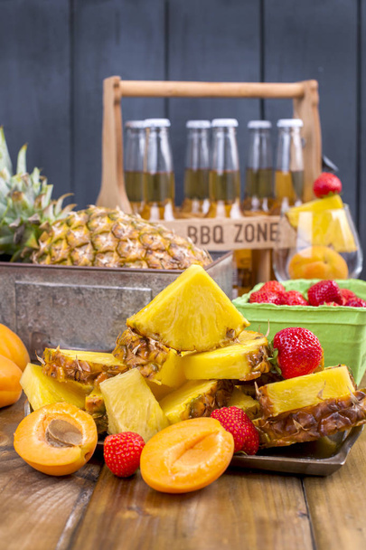 frutas tropicais maduras de suco e coquetel em uma festa. Uma caixa de cerveja e um fundo de madeira. Foto vintage. Espaço de cópia
, - Foto, Imagem
