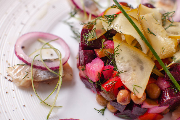 frische hausgemachte Rote-Bete-Salatvinaigrette mit Heringsfisch in einer weißen Schüssel. traditionelles russisches Essen. - Foto, Bild