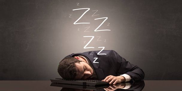 Businessman fell asleep at the office on his keyboard - 写真・画像