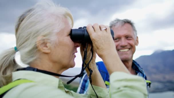 Felice coppia caucasica in pensione con binocolo godendo vacanza escursionismo di The Remarkables Lago Wakatipu Nuova Zelanda
 - Filmati, video