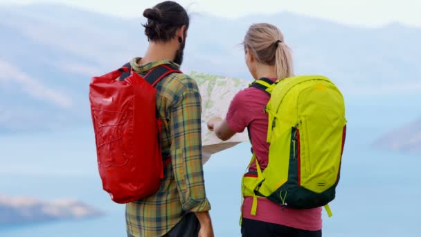 Viajeros activos de aventura caucásica disfrutando de su recorrido de senderismo y planificación leyendo el mapa de Mount Aspiring Lake Wakatipu Nueva Zelanda
 - Metraje, vídeo