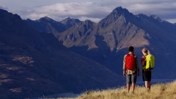 Jonge Kaukasische avontuur reizigers met rugzakken wandelen wildernis van The Remarkables Fiordland Nationaalpark Nieuw-Zeeland Red wapen - Video