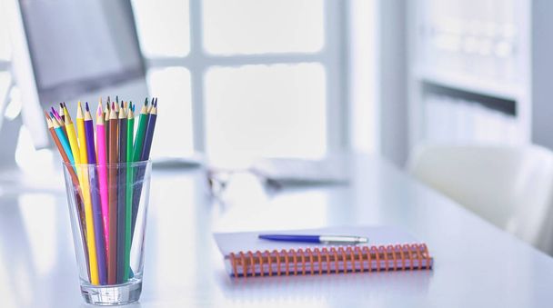 Crayons de graphite dans un récipient en verre sur la table de bureau
. - Photo, image