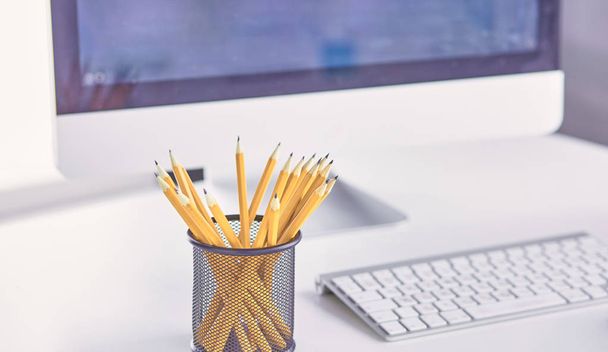 Графитовые карандаши в металлической сетке-контейнере на рабочем столе
. - Фото, изображение