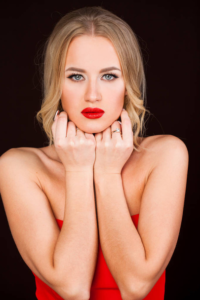 Portrait of beautiful young adult attractive sexy and sensuality blonde woman in red elegance fashionable dress isolated on dark background - Fotó, kép