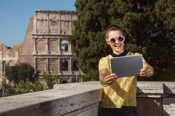 smiling modern tourist woman in yellow blouse taking selfie with tablet PC near Colosseum , Rome, Italy - Photo, Image